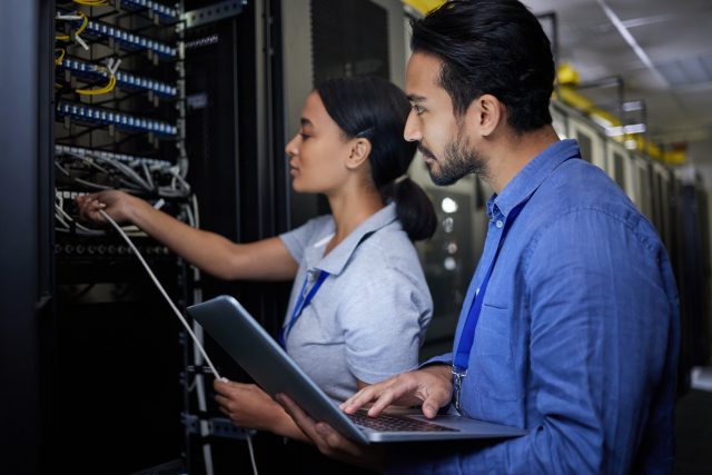 Man, woman or server room maintenance on laptop IT, software programming ideas or cybersecurity engineering. People, repair or data center technology in teamwork collaboration of safety analytics fix