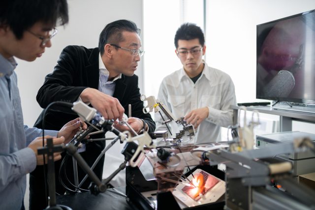 Engineering students and professor working together. Osaka, Japan. March 2018